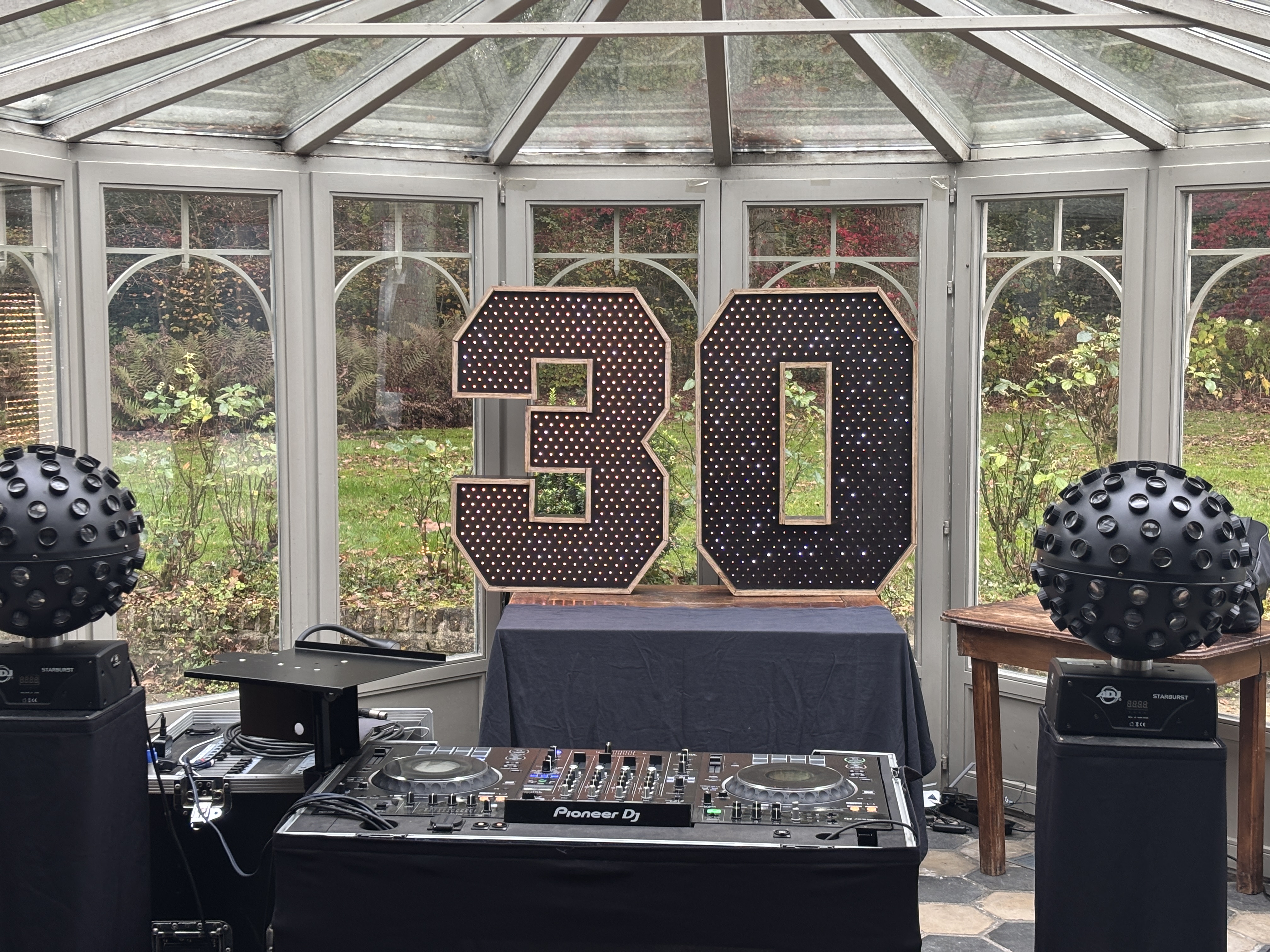 LED cijfers 30 in warme goudtinten tussen DJ-setup